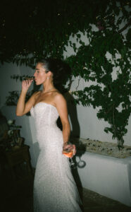 Stylish bride enjoying a cigar and a glass of wine at her wedding party