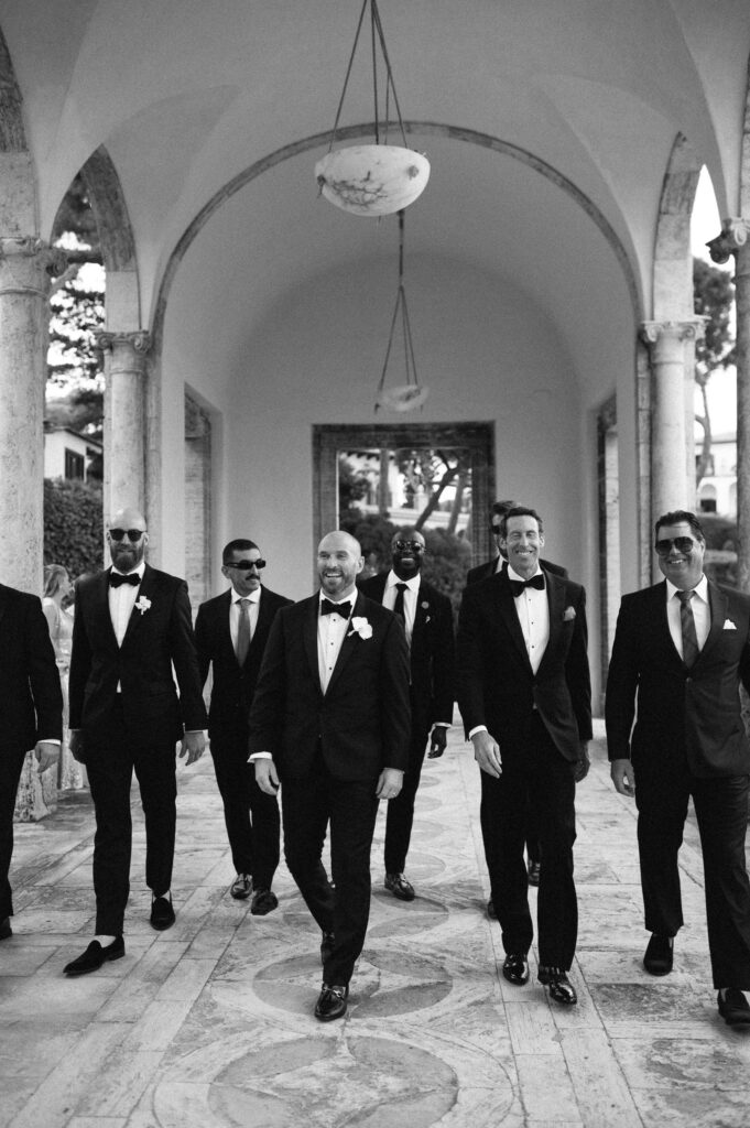 Black and white documentary photograph of wedding guests walking together