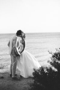 Black and white photograph of a newlywed couple by the Mediterranean sea