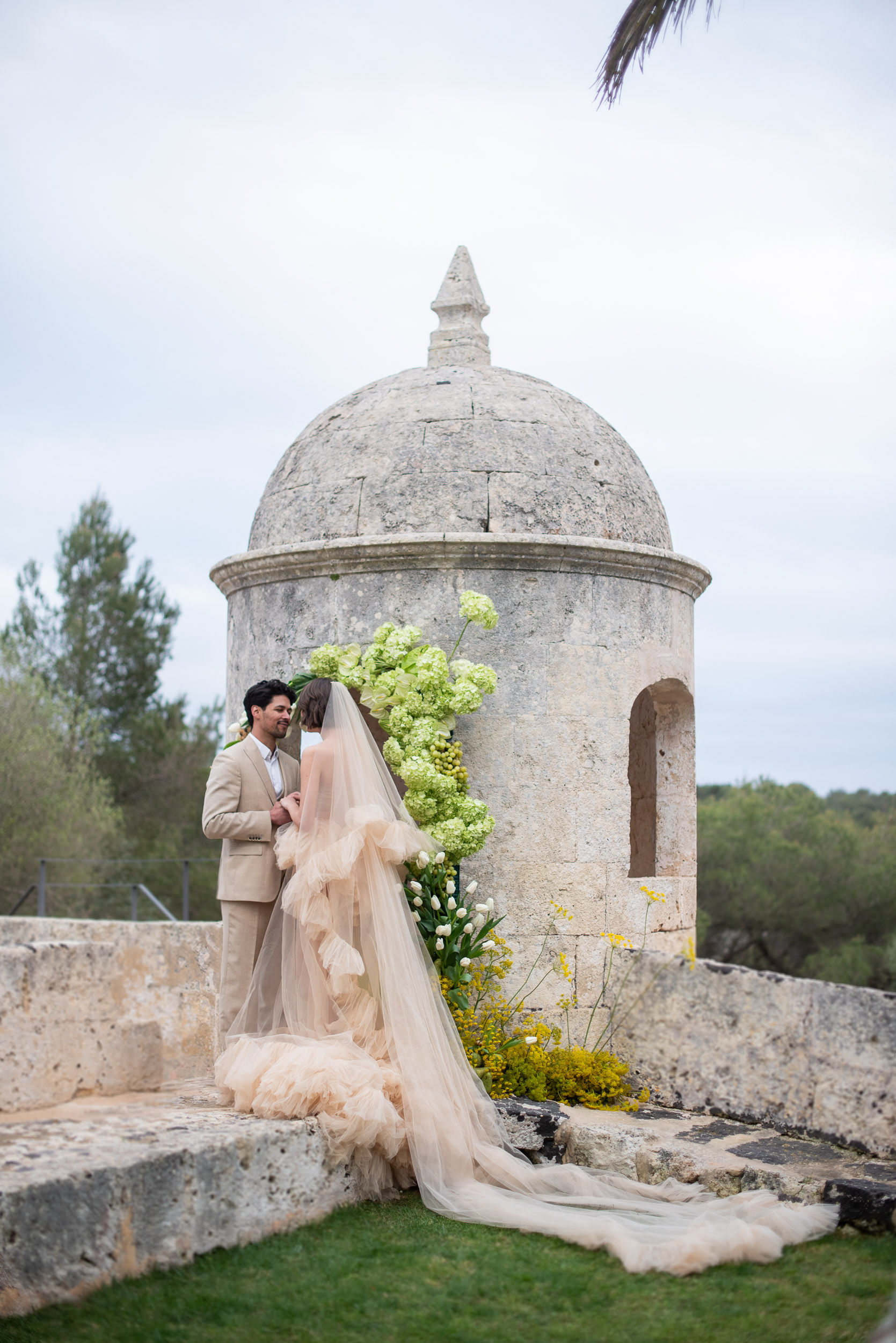 Couple walking through the Mediterranean landscape at a destination wedding in Menorca