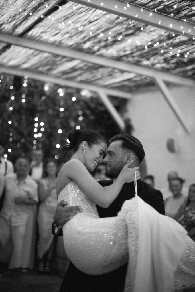 Black and white photograph of a newlywed couple sharing a spontaneous moment